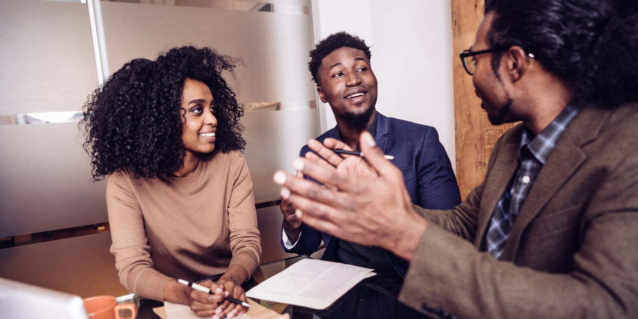 Un groupe de collaborateurs discute en réunion