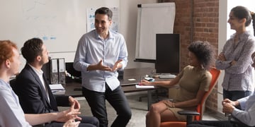 un homme qui décrit ses avancement lors d'un travail en équipe